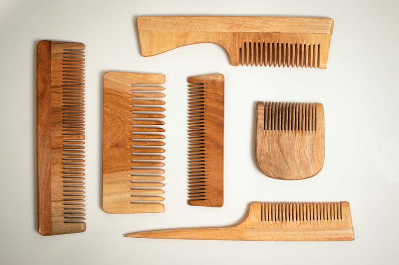 Team of diverse men holding premium beard combs in a sunlit grooming studio
